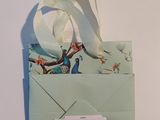 a small envelope with a ribbon on top of it