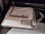 a person holding a stack of papers in an oven