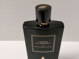 a close up of a bottle of perfume on a white surface
