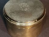 a gold box with a monogram on the lid