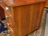 a wooden desk with drawers and a rug on the floor