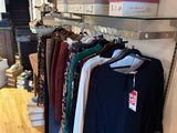 a lot of clothes hanging on a rack in a store