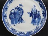 deux assiettes bleues et blanches ornées de personnages, posées sur une table