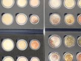 several different types of coins are displayed in a display case