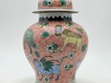 an image of a pink and green vase with a lid on a white background