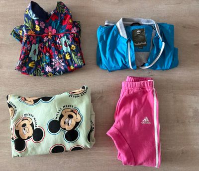 three pieces of clothing are laid out on a wooden floor