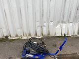 a blue cart with a hose attached to it on the side of the street