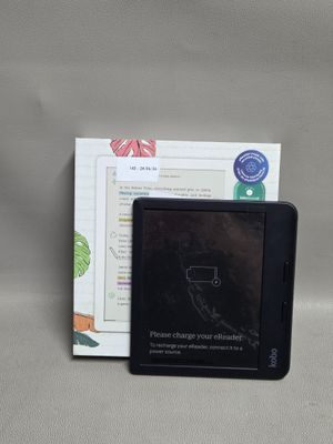 un petit appareil électronique posé à côté d'un livre