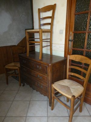 une commode en bois et une chaise dans une pièce