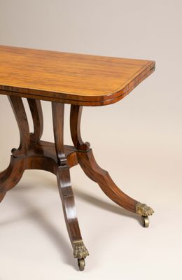 La table est en bois et ses pieds sont équipés de roulettes.