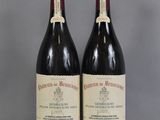 two bottles of red wine sitting on top of a table