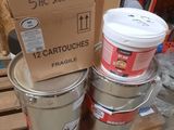 three buckets of paint sitting on a pallet next to a cardboard box