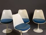 three white and blue tulip chairs sitting on top of each other