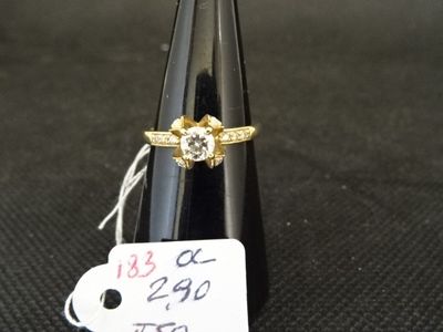 une bague en or sertie d'un diamant au sommet d'un cône noir