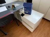 a desk with a computer on it in the corner of a room