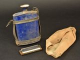a blue bottle and a leather case on a black surface