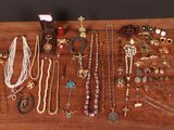 many different necklaces and bracelets laid out on a table