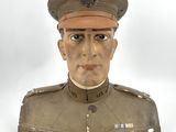 une statue représentant un homme en uniforme sur fond blanc