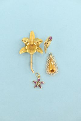 a gold brooch and earring set on a blue surface