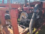 a red tractor that is parked in the grass