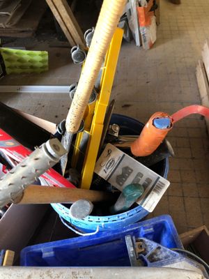 un seau rempli d'outils divers posé par terre