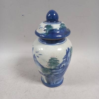 un vase bleu et blanc avec un couvercle sur une table