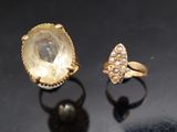 deux bagues en or et une bague en diamant posées sur un fond noir