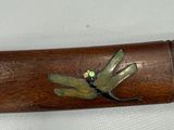 a wooden stick with a dragonfly on it