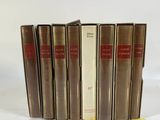 six books are lined up in a row on a white surface