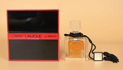 un flacon de parfum posé sur une table, à côté d'une boîte