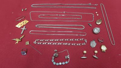 a lot of silver jewelry on a red surface