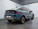 the rear end of a blue car parked in a garage