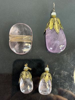 three pieces of jewelry on display in a glass case