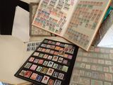 beaucoup de timbres posés sur une table, à côté d'un livre