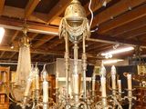 a chandelier in the middle of a room with many tables and chairs