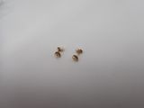 a pair of gold stud earrings on a white plate