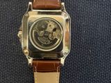 an image of a close up of a watch on a blue surface