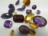 purple and yellow gems are scattered on a white surface