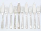 six couteaux argentés et six couteaux sur une surface blanche