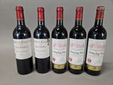 four bottles of wine are lined up on a table