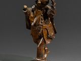 une statue en bronze représentant un homme coiffé d'un chapeau et vêtu d'un manteau, tenant un sac