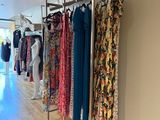 a lot of clothes hanging on a rack in a room