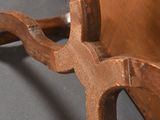 a wooden chair that has a metal handle on it