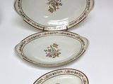 three plates with floral designs on them sitting on a white surface