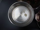 overhead view of a metal bowl with a spoon and spoon rest on a table