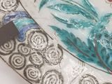 a decorative plate with a bird and flowers on it