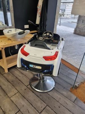 une voiture blanche garée sur un fauteuil de coiffeur