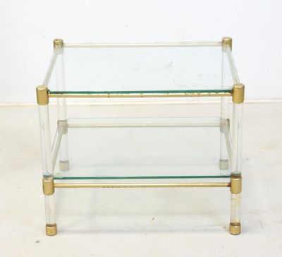 a glass and brass coffee table with three shelves