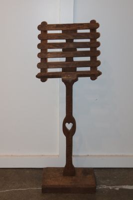 a wooden sign on a stand with a heart on it