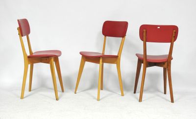 trois chaises rouges placées les unes à côté des autres sur une surface blanche